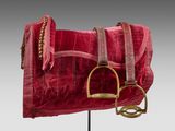 a close up of a red purse on a metal stand