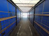 a long hallway with blue walls and wooden benches