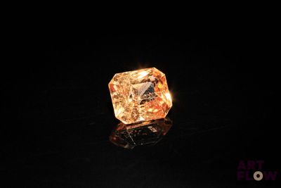 a close up of a diamond on a black surface with a black background