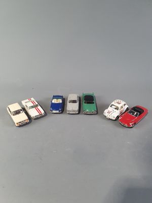 several toy cars are lined up in a row on a gray surface