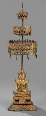 a gold cake stand with a statue on top of it