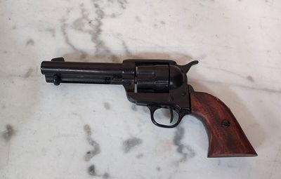 un revolver posé sur un plan de travail en marbre, muni d'une crosse en bois