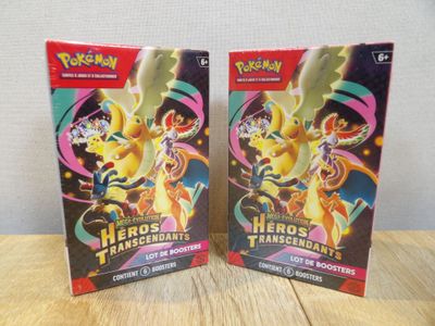 deux boîtes de cartes à collectionner Pokémon posées sur une table en bois