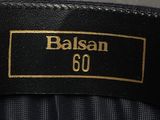 a close up of a black and gold label on a suit