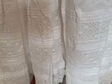 a white dress hanging on a rack in a room