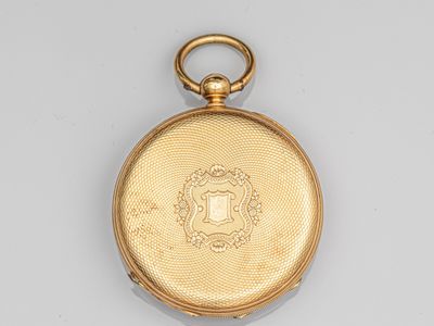 a close up of a gold pocket watch on a white surface