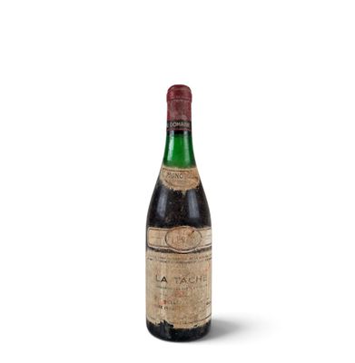an old bottle of wine sitting on top of a white surface