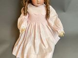 an image of a doll with red hair and a pink dress