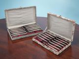 two open cases that have ties in them on a table