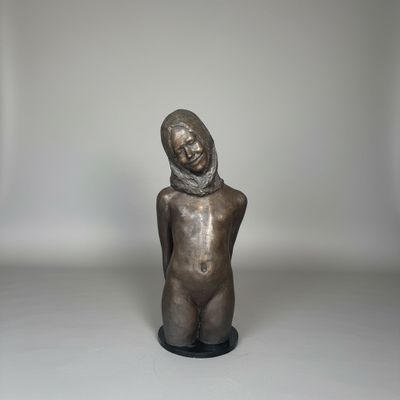 bronze statue of a woman with a scarf on her head