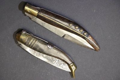 deux couteaux sont posés côte à côte sur une table