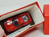 a red toy car in a red box on a table