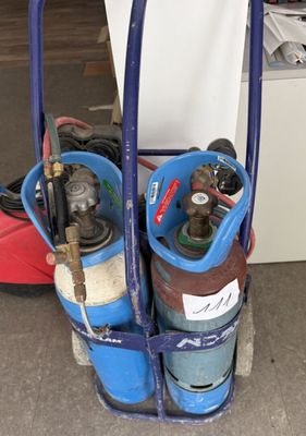 un chariot sur lequel sont fixées des bouteilles de gaz et un tuyau
