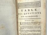 un livre ouvert, muni d'une étiquette, posé sur une table