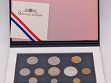 a box with six different coins inside of it on a white surface