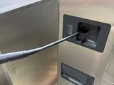 a silver refrigerator with a black handle in a warehouse