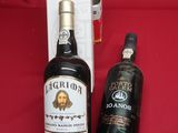 two bottles of liquor sitting on a red table next to a bottle of liquor