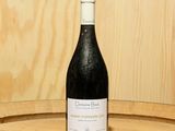 une bouteille de vin posée sur un tonneau