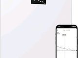 an image of a white bathroom scale with a cell phone next to it