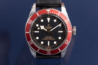 a black and red watch on a blue surface
