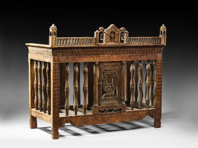 un vieux berceau en bois orné de sculptures sur les côtés