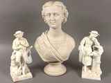 trois figurines représentant une femme et un homme, posées sur un socle