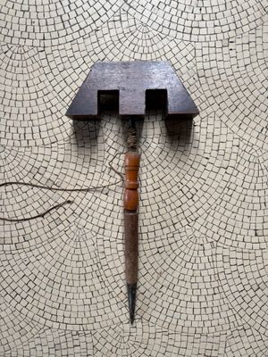 a knife stuck in the middle of a piece of tile