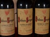 three bottles of red wine are lined up on a table
