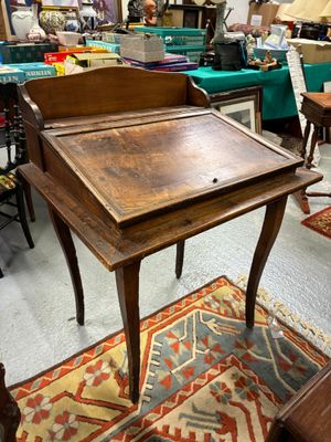 un bureau en bois avec un plateau en bois, dans une pièce remplie de meubles