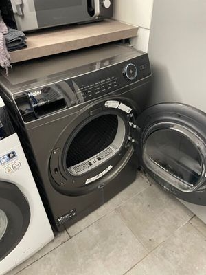 two washers and a dryer in a small room