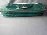 a green bag that is sitting on top of a bed