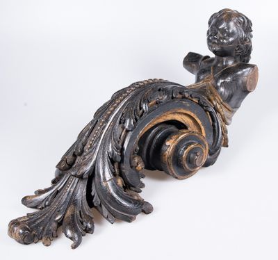 a statue of a boy sitting on top of a scroll