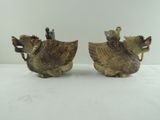 pair of antique ceramic rooster figurines on a white table