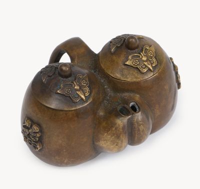 bronze figurine of a cat with a teapot on its back