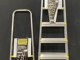 two step ladders are standing next to each other in front of a wall