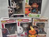 cinq figurines Funko de différentes tailles et couleurs sont posées sur une table