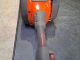 un aspirateur orange et gris posé par terre