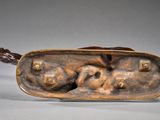 bronze sculpture of a man and woman in a boat on a gray surface