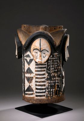 un gros plan d'un vase en bois sur lequel est représenté un visage