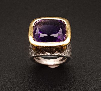 Gros plan sur une bague ornée d'une pierre violette