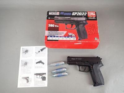 a gun that is sitting on a table next to a box
