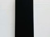 the back of a black phone sitting on top of a white table
