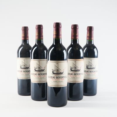 four bottles of red wine are lined up on a white surface