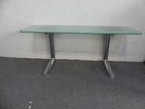 une table en verre avec des pieds en métal et un plateau en verre