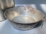 a large metal bowl sitting on a table next to a can