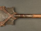 a close up of a wooden handled shovel on a gray surface