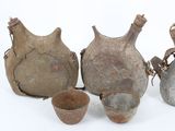 several old vases and bowls are sitting on a white surface