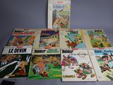 several comics are lined up on a table next to a lamp