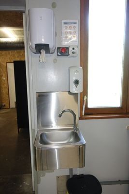 un lavabo et une poubelle dans un coin de la pièce