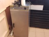 une photo d'un petit réfrigérateur dans un coin d'une pièce